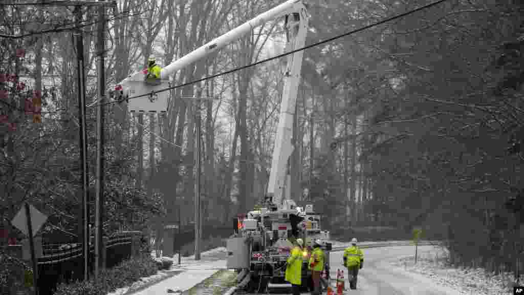 Les employés de Duke Energy, une campagne électrique, travaillent pour rétablir le courant dans un quartier à Matthews, Caroline du Nord, 22 janvier 2016. Une tempête de neige massive a commencé à tomber sur le sud et l&#39;est des États-Unis avec des annulations de vols de masse, cinq Etats déclarant l&#39;état d&#39;urgence et plus de 2 pieds (60 centimètres) prédit pour Washington seul. &nbsp;