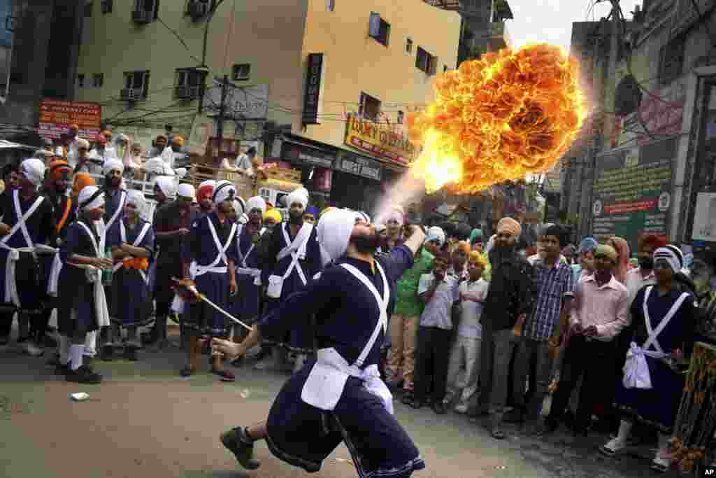 A Sikh youth performs an act of fire as he displays martial art skills during a religious procession on the eve of birth anniversary of Guru Ram Das in Amritsar, India. Ram Das was the fourth of the ten gurus of Sikhism.