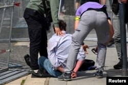 Policajci u civilu privode čoveka na mestu pucnjave u gradu Handlova (Foto: Reuters/Radovan Stoklasa)