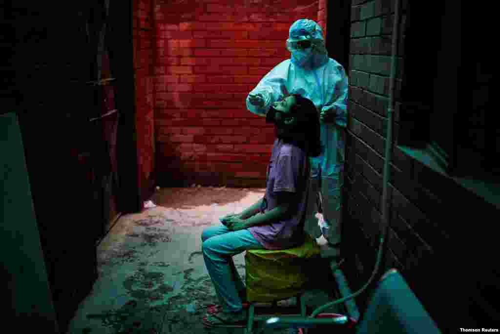 신종 코로나 바이러스 일일 확진자 수 세계 최고를 기록한 인도 뉴델리의 보건소에서 개인보호장비를 입은 의료원이 코로나바이러스 감염 검사을 위해 샘플을 채취하고 있다.