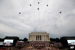 美国海军蓝天使特技飞行队的飞机飞过林肯纪念堂的上空，特朗普总统和第一夫人梅拉妮亚、副总统彭斯等人站立观看，美国陆军乐队演奏。(2019年7月4日)