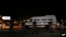 Polisi Israel berjaga-jaga saat mobil yang membawa tahanan Palestina ke Jalur Gaza lewat (13/8).