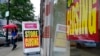 FILE - A passer-by is shown near a storefront with closing signs in Boston, Sept. 2, 2020. The U.S. unemployment rate dropped to 7.9% in September, but hiring is slowing and many Americans have given up looking for work, federal officials say.