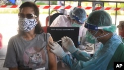 A health worker administers a dose of the AstraZeneca COVID-19 vaccine to a resident of the Klong Toey area, a neighborhood currently having a spike in coronavirus cases, in Bangkok, Thailand, Monday, May 10, 2021. (AP Photo/Vichan Poti) 