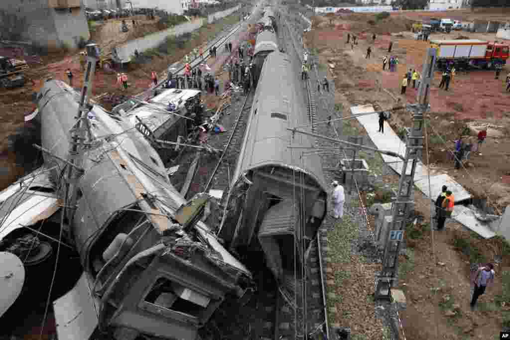 People gather after train derailed&nbsp; near Sidi Bouknadel, Morocco. A shuttle train linking the Moroccan capital Rabat to a town further north on the Atlantic coast derailed, killing several people and injuring dozens, authorities and the state news agency said.
