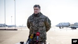 Presiden Ukraina Petro Poroshenko berbicara dengan media di bandar udara Borispol di luar Kyiv (18/2). (AP/Mikhail Palinchak)