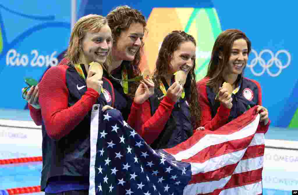 Tim perenang putri Amerika Serikat, dari kiri ke kanan, Katie Ledecky, Allison Schmitt, Leah Smith dan Maya DiRado, memegang medali emas mereka setelah memenangkan nomor estafet putri 4x200 meter dalam Olimpiade 2016 di Rio de Janeiro (11/8). (AP/Lee Jin-man)