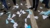 People stand next to paper planes, symbol of Telegram messenger, released during a rally in protest against court decision to block the messenger because it violated Russian regulations, in Moscow, April 30, 2018. 