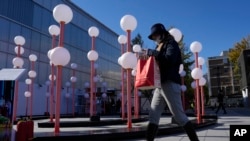 2023年11月11日，周六，一名购物者走过北京的一个购物中心。(美联社）