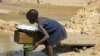 A girl separates gold dust from sand extracted by miners at the Nadom Koundo site near the village of Kette, some 40 kms from the eastern Cameroonian town of Batouri, June 2, 2008. Authorities are trying to get child miners back to school.