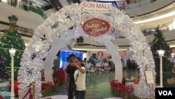 ប្រជាជន​កម្ពុជា​ថតរូប​ជាមួយ​នឹង​ការតុបតែង​សម្រាប់​ពិធីបុណ្យ​គ្រីស្តម៉ាស​ដែល​ជាបុណ្យ​របស់​សាសនា​គ្រឹស្ត​នៅ​ក្នុងផ្សារ​ទំនើប​កាល​ពីថ្ងៃ​ទី២៤ ខែ​ធ្នូ ឆ្នាំ២០១៨ ក្នុង​រាជធានី​ភ្នំពេញ។ (ទុំ ម្លិះ/VOA) 