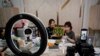 In this May 5, 2020, photo, China's online celebrity Zhang Mofan, right, introduces fresh mangos to her online clients and fans through the live-streaming at her house in Beijing. Retailers in China are embracing livestreaming as a sales channel…