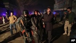 2014年1月17日，阿富汗首都喀布尔一家餐馆发生爆炸后，安全警卫协助现场受害人员前往医院治疗