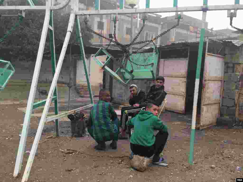 Para pengungsi berkumpul di bangunan yang rusak di Mosul, yang baru-baru ini diambil alih oleh tentara Irak. Pada malam hari, mereka mengatakan ada hujan mortir dan mereka harus tinggal di dalam ruangan (2/12). (VOA/H.Murdock)