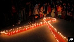 Perempuan dan anak-anak Nepal dari “Maiti Nepal”, pusat rehabilitasi korban perdagangan seks, menyalakan lilin berbentuk pita merah malam menjelang peringatan Hari AIDS Sedunia yang jatuh setiap 1 Desember, di Kathmandu. (AP/Niranjan Shrestha)