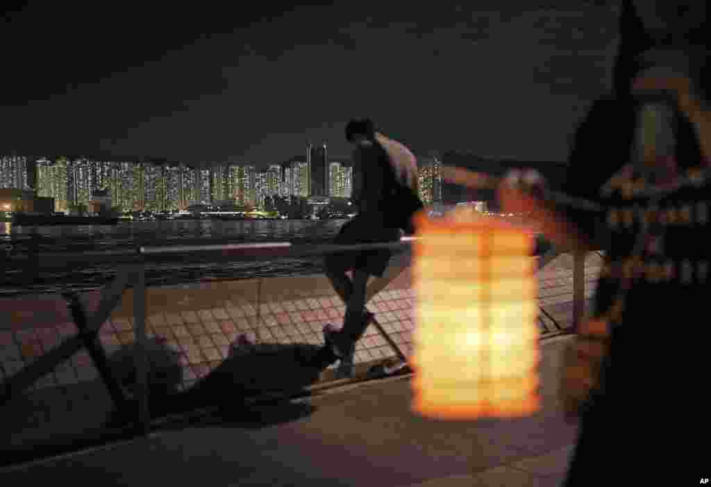 Penduduk mengangkat lentera selama Festival Pertengahan Musim Gugur China di sebuah taman di Hong Kong.