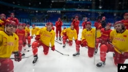 参加北京冬奥会的中国冰球队运动员在赛前练习时倾听教练讲话。（2022年1月30日）