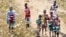 Local youth and children stand in a swarm of locust flying over in Soatana village, southern Madagascar on May 29, 2011.