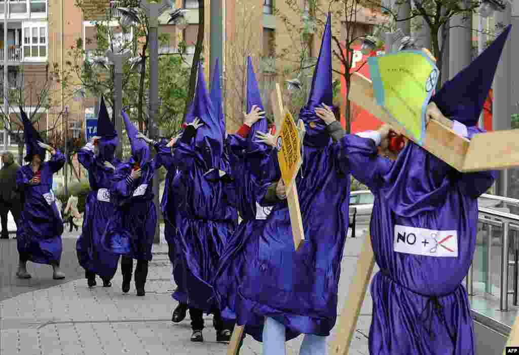 Para pegawai kantor pengadilan di kota Baracaldo, Spanyol mengenakan kostum dan membawa kayu salib dalam aksi untuk memprotes pemotongan anggaran pemerintah bagi layanan pengadilan.