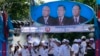 Supporters of Prime Minister Hun Sen's Cambodian People's Party dance under portraits of the party leaders, from left, Chea Sim, Hun Sen and Heng Samrin, during an election campaign in Phnom Penh, Cambodia, Thursday, June 27, 2013. Cambodia's political parties on Thursday kicked off campaigning for the July 28 general election, which is almost certain to see the return to power of Asia's longest-serving leader, Hun Sen.