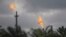 FILE - Gas flares belonging to the Agip Oil company are seen across farmland in Idu, Niger Delta area of Nigeria, Oct. 8, 2021. 