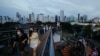 Warga mengenakan masker saat berjalan-jalan di sepanjang jembatan skywalk di tengah merebaknya varian Omicron di Jakarta, 7 Februari 2022. (REUTERS/Willy Kurniawan).
