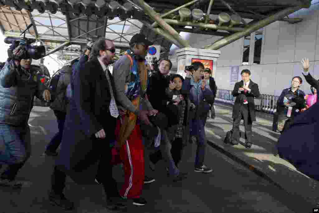 Mantan bintang NBA Dennis Rodman (tengah) tiba di bandar udara Beijing, China (19/12). (AP/Ng Han Guan)