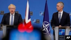 英国首相约翰逊（左）和北约秘书长斯托尔滕贝格在记者会上。