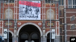 Poster pertunjukan “Revolusi! Kemerdekaan Indonesia” terpampang di luar Museum Nasional di Amsterdam, Belanda, 9 Februari 2022. Pertunjukkan itu menampilkan perjuangan Indonesia merebut kemerdekaan setelah Perang Dunia II berdasarkan penuturan 23 saksi. (Foto: Mike Corder/AP)