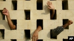 Zatvorenici osuđeni na smrt u Abu Graibu, 20. oktobra 2002. Stotine Iračana je upalo u zatvor posle objave Sadama Huseina da će većina zatvorenika biti oslobođena. (Foto: AP/Jerome Delay)