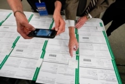 FILE - A canvas observer photographs Lehigh County provisional ballots during vote counting in Allentown, Pennsylvania, November 6, 2020.