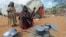 Kadija Mohamed cooks food for her children in a camp set up for internally displaced people in Dinsoor, in southern Somalia, January 5, 2012.