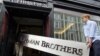 The Lehman Brothers corporate sign in polished metal is taken into an auction house in London, Friday, Sept. 24, 2010.