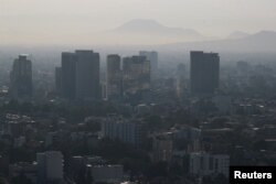 Buildings and houses stand shrouded in smog as authorities ordered traffic restrictions due to air pollution in Mexico City, Mexico, March 7, 2024. (REUTERS/Henry Romero)