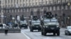 Ukrainian military vehicles move past Independence Square in central Kyiv, Feb. 24, 2022, after cities were hit with what Ukrainian officials said were Russian missile strikes and artillery.