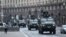 Ukrainian military vehicles move past Independence Square in central Kyiv, Feb. 24, 2022, after cities were hit with what Ukrainian officials said were Russian missile strikes and artillery.