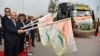 India’s foreign secretary Harsh Vardhan Shringla, 2nd left, and Afghanistan’s ambassador to India Farid Mamundzay, left, flag off the trucks carrying wheat from India at the Attari-Wagah border between India and Pakistan, near Amritsar, India, Feb. 22, 2022.