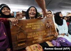 Sejumlah janda korban pembantaian oleh tentara Belanda saat perang kemerdekaan pada 1947 menerima kompensasi dari pemerintah Belanda dalam sebuah acara di monumen peringatan di Rawagede, Jawa Barat, 9 Desember 2011. (Foto: Romeo Gacad/AFP)