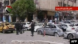 Foto yang diambil dari TV Pemerintah Suriah ini menunjukkan polisi Suriah tengah memeriksa lokasi sekitar ledakan di distrik Marjeh, pusat kota Damaskus, 30 April 2013 (AFP Photo/Syrian TV)