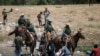 U.S. Customs and Border Protection mounted officers attempt to contain migrants as they cross the Rio Grande from Ciudad Acuña into Del Rio, Texas, Sept. 19, 2021.