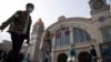 Travelers with their luggage walk past the Hankou railway station on the eve of its resuming outbound traffic in Wuhan in central China's Hubei province on Tuesday, April 7, 2020. Starting Wednesday, residents of Wuhan will be allowed to once again…