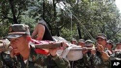 7일 중국 남서부 윈난성 지진현장에 투입된 중국 공안들이 부상자를 옮기고 있다.