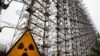 FILE - A Soviet-era top secret object Duga, an over-the-horizon radar system once used as part of the Soviet missile defense early-warning radar network, is seen behind a radioactivity sign in Chernobyl, Ukraine, on Nov. 22, 2018. 