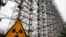 FILE - A Soviet-era top secret object Duga, an over-the-horizon radar system once used as part of the Soviet missile defense early-warning radar network, is seen behind a radioactivity sign in Chernobyl, Ukraine, on Nov. 22, 2018. 