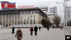 Warga Korea Utara berjalan di lapangan Kim Il Sung, Pyongyang (19/3). Para diplomat asing masih bertahan di Pyongyang meski ketegangan meningkat antara dua Korea. 