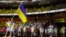 Olena Kostevych and Bogdan Nikishin, of Ukraine, carry their country's flag during the opening ceremony in the Olympic Stadium at the 2020 Summer Olympics, July 23, 2021, in Tokyo, Japan.