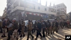 Des soldats syriens et turcs marchent dans le centre ville d'Afrine, Syrie, le 18 mars 2018 