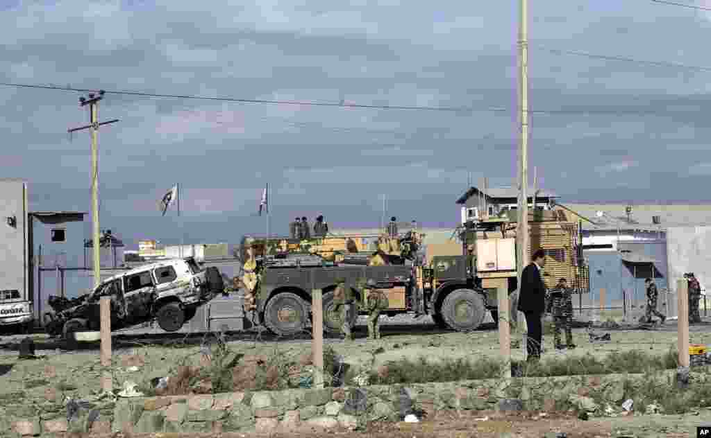 U.S. soldiers remove a destroyed vehicle from the site of a suicide attack in Kabul, Afghanistan, Oct. 13, 2014.