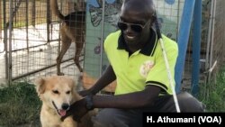 Francis Okello Oloya, founder of The Comfort Dog Project, interacts with Binongo in Gulu, Uganda.