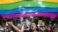 Para aktivis dan pendukung komunitas LGBTQ+ melambaikan bendera pelangi dalam demo di Kolkata, Indian, 1 September 2024. (Foto: Dibyangshu Sarkar/AFP)
